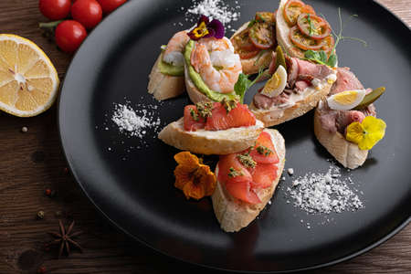 Brusquettes, Assorted, Fish, Prawns, Meat, Vegetables, Seafood, on a black backgroundの写真素材