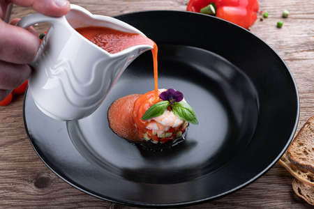 Gazpacho cold soup with shrimp on a black plateの写真素材