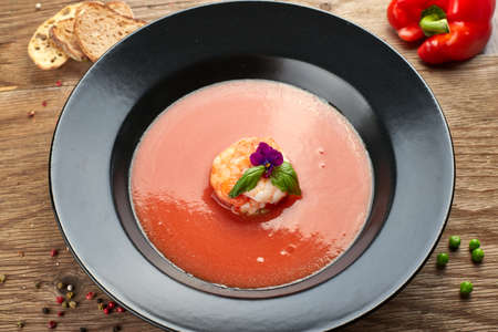 Gazpacho cold soup with shrimp on a black plateの写真素材