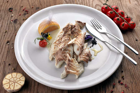 Fried Sibas fish on a white plateの写真素材