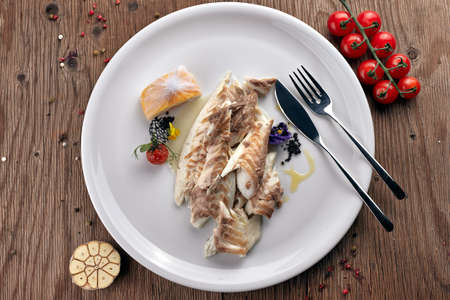 Fried Sibas fish on a white plate