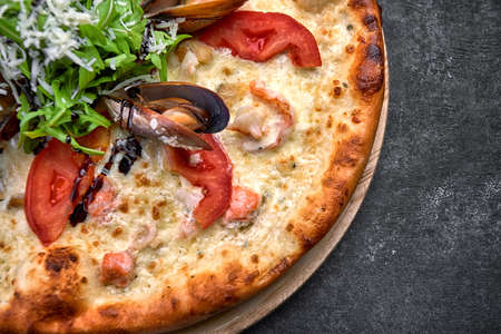 Pizza with seafood on a dark background, shrimp mussels squid. Horizontal shallow depth of fieldの写真素材