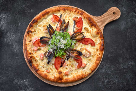 Pizza with seafood on a dark background, shrimp mussels squid. Horizontal shallow depth of fieldの写真素材