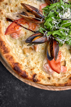 Pizza with seafood on a dark background, shrimp mussels squidの写真素材