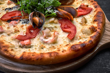 Pizza with seafood on a dark background, shrimp mussels squid. Horizontal shallow depth of fieldの写真素材
