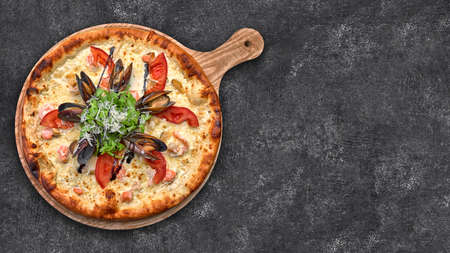 Pizza with seafood on a dark background, shrimp mussels squid. Horizontal shallow depth of fieldの写真素材