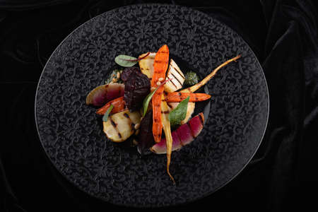 Vegetables a grill on a black plateの写真素材