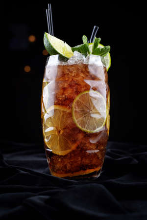 Alcoholic cocktail, Long island ice tee, on black velvet, on a black background with lime and mintの写真素材