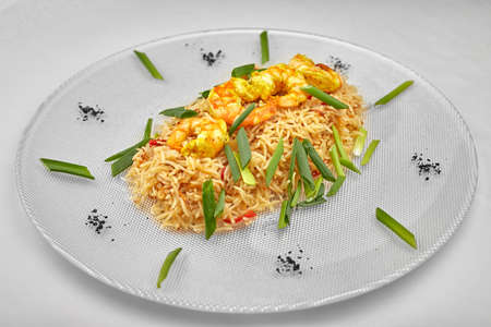 Pilaf with shrimp on a white plateの写真素材