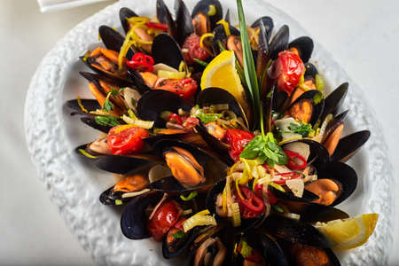 Mussels on a white plate on a white backgroundの写真素材