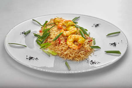 Pilaf with shrimp on a white plateの写真素材