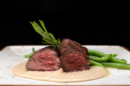 Filet mignon with asparagus on a light plate, on a dark backgroundの写真素材