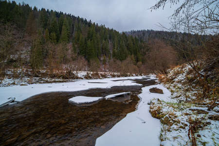 Winter river in the mountains in a cloudy rogoda. Winter landscapeの写真素材
