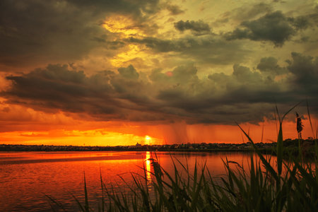 Sunset on the lake reeds reflections and cloudsの写真素材