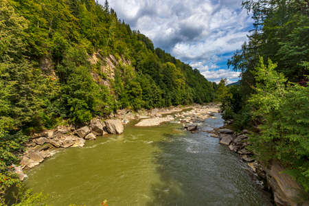Carpathian landscape, mountains, trees, river, against the blue sky