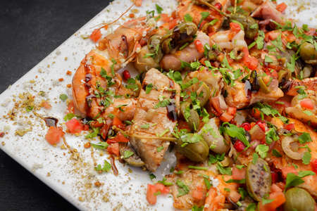 Seafood cocktail scallop, shrimp, fish, squid, with capers and herbs on a plateの写真素材