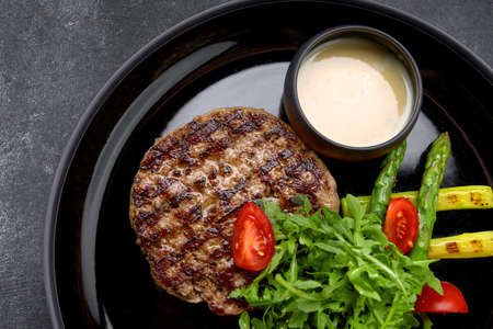 Pork steak with sauce, herbs and tomatoesの写真素材