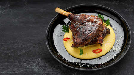 Fried leg of lamb with garnish and pepper, on a dark backgroundの写真素材