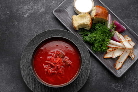 Ukrainian borscht with donuts, sour cream, lard and dill, on a dark backgroundの写真素材