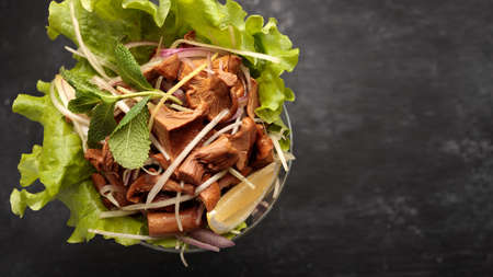 marinated chanterelle mushrooms with onions and spices, on a lettuce leaf, in a glass