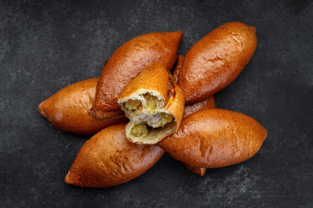 Several baked pies with potatoes on a dark backgroundの写真素材