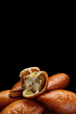 Several baked pies with potatoes on a dark backgroundの写真素材