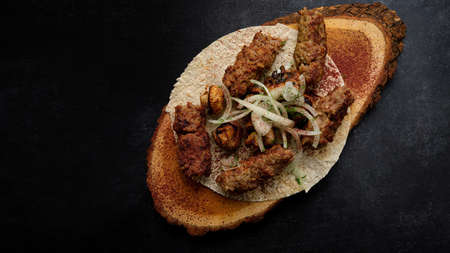 Lula-kebab with spices and grilled champignon mushrooms, on a wooden