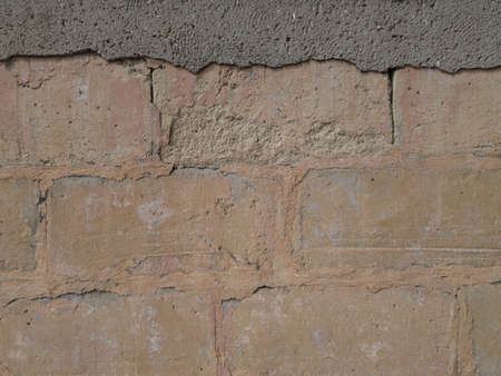 Rough texture of a stone wall with traces of cement and paint