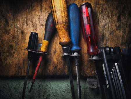 Dirty work tools on a grunge wall in a workshop. Illustrationの写真素材