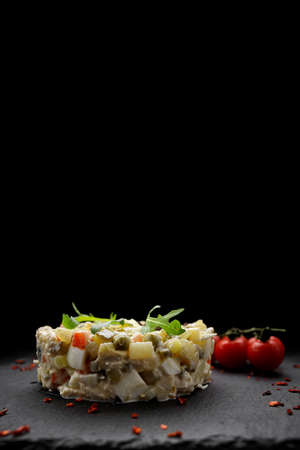 Salad Olivier on a black background, verticalの写真素材