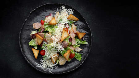 Caesar salad on a black plate. Horizontalの写真素材