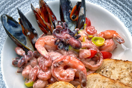 Mix of seafood, mussels, octopus, shrimp, scallops with vegetables in cream sauceの写真素材