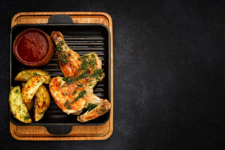 Half chicken fried with fried potatoes and barbecue sauceの写真素材