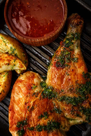 Half chicken fried with fried potatoes and barbecue sauce. Verticalの写真素材