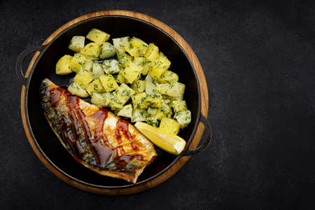 Baked mackerel fish fillet with potatoes in a pan