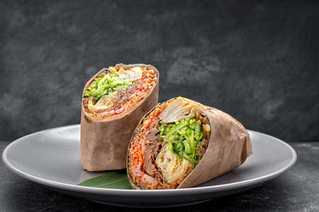 Sushi roll with turkey and scrambled eggs, temaki, on a plate, on gray concreteの写真素材