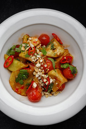Pickled eggplants with tomatoes, nuts and spices on a plateの写真素材