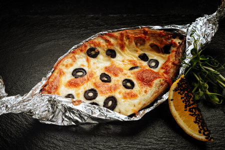 Mackerel stuffed with cheese, with olives, on a black backgroundの写真素材