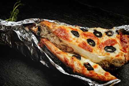 Mackerel stuffed with cheese, with olives, on a black backgroundの写真素材