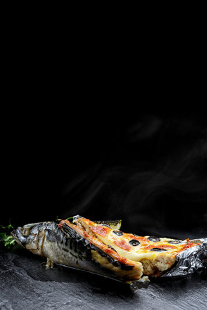 Mackerel stuffed with cheese, with olives, on a black backgroundの写真素材