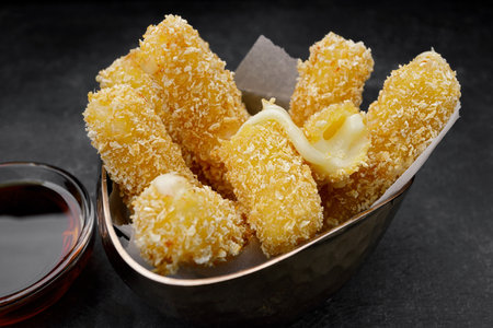 Fried nuggets with cheese and jam, on a dark background