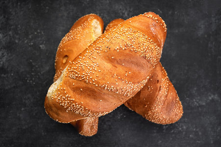 White baked bread with seeds, on gray concrete
