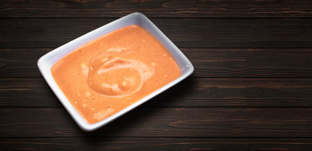 Sweet mustard sauce in a white sauce pan, on a wooden backgroundの写真素材