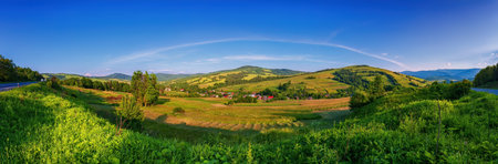 Mountain panorama, valleys, flowers, blue sky and white cloudsの写真素材