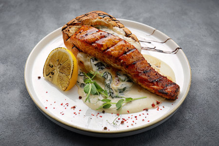 Grilled salmon fillet steak with sauce and ciabatta, on a gray backgroundの写真素材