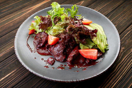 savory salad featuring liver, avocado, juicy strawberries, and crisp greensの写真素材