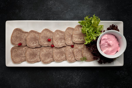 Boiled and sliced tongue with greens and mayonnaise, a delicious banquet option