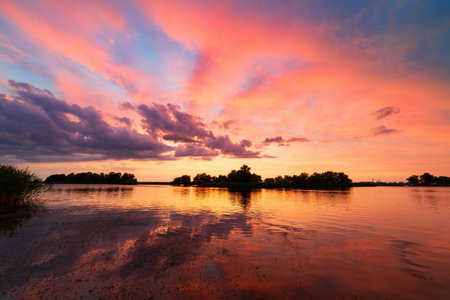 beautiful landscape adorned with bright red clouds and their watery reflection, sunrise
