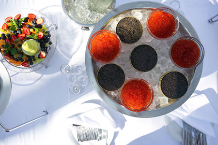 Covered and served furshet table, outdoor. Red and black caviar and fruitsの写真素材