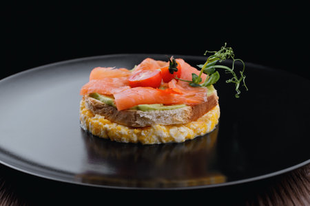 Breakfast, bread toast with scrambled eggs, salmon, avocado and tomatoesの写真素材